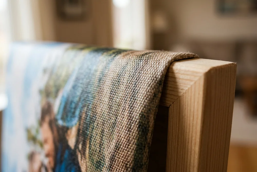 Macro close-up of woven canvas fabric wrapped over the edge of a pine stretcher bar