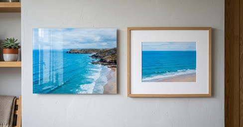 An acrylic print and a framed print of the same scene hung side by side on a living room wall