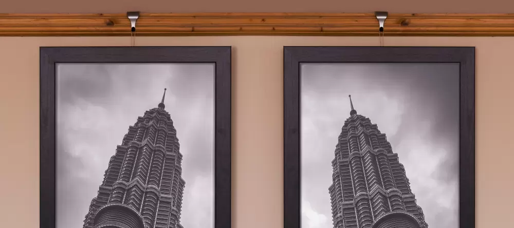 Hanging pictures without nails. Two pictures on wall showing architecture towers