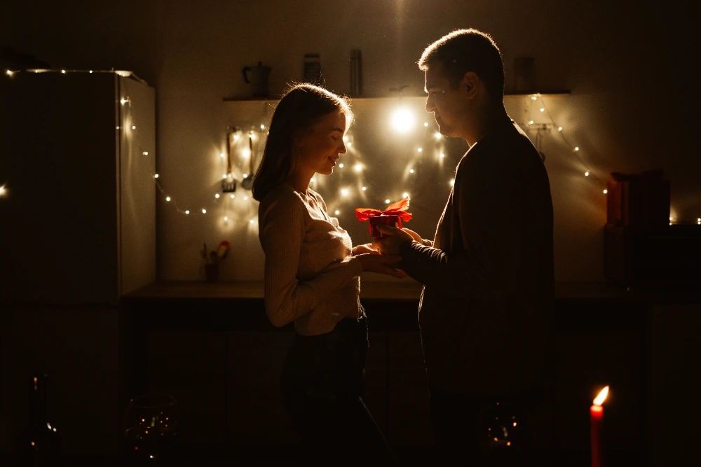 A romantic couple celebrating a birthday with a bouquet of flowers and a special moment, reflecting heartfelt birthday messages for partners.