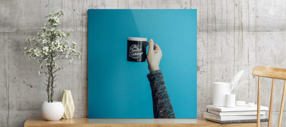 Metal vs Acrylic Prints: Which is Better? Beautiful acrylic photo print with hand holding mug.