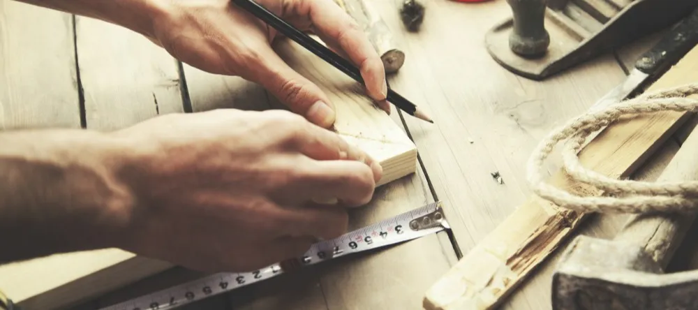 How Much Does a Canvas Print Cost? Man working on wooden frame for canvas.