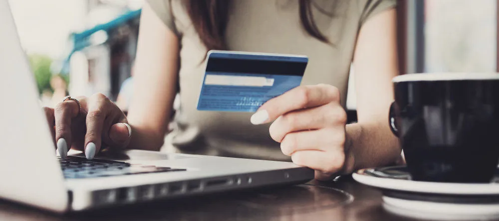 How Much Does a Canvas Print Cost? Woman holding her credit card for online shopping.