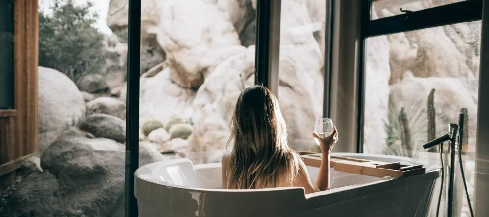 Can You Hang Canvas Prints in a Bathroom? Woman enjoying glass of wine in tub.