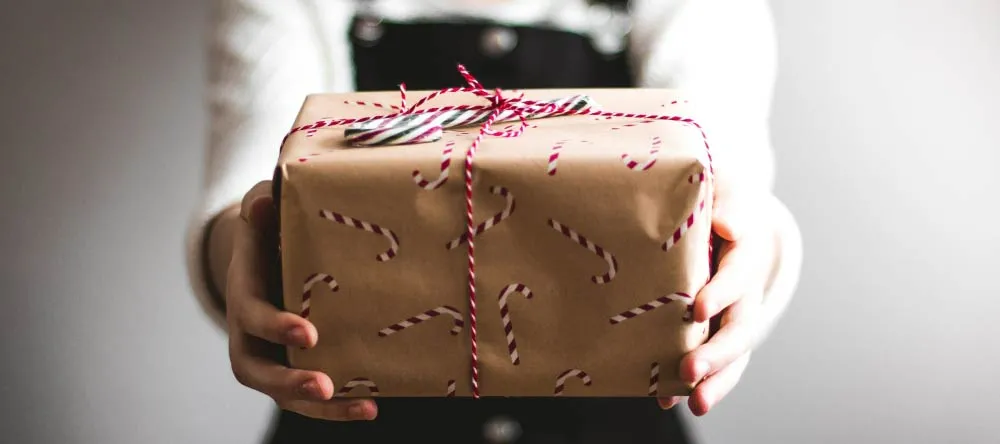 Personalised Photo Christmas Cards. Closeup photo of woman holding Christmas gift.