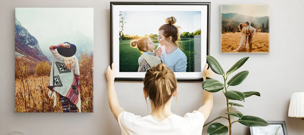 How to Frame a Picture: The Effortless Solution. Young woman setting up framed picture for a display on a gallery wall.