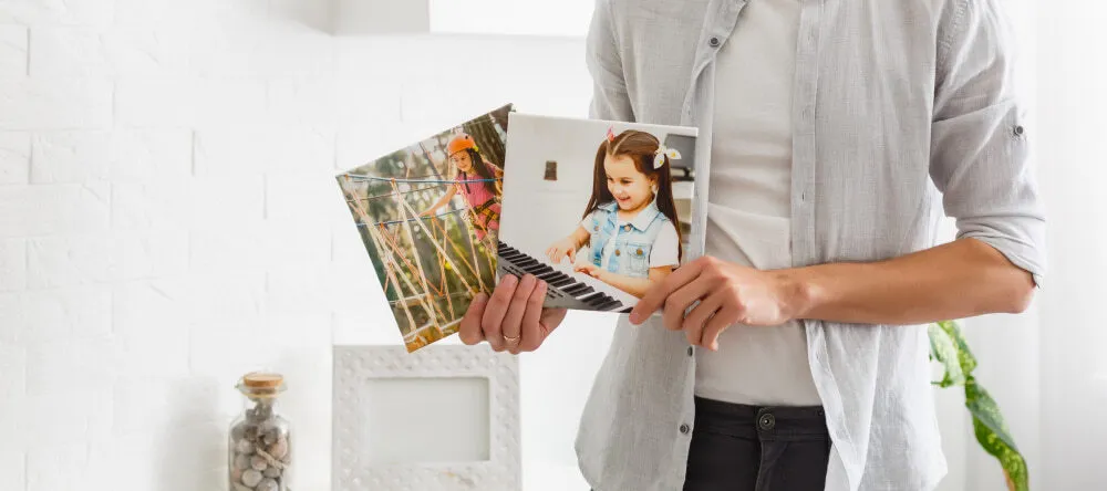 Small pictures for walls: a man holding two small canvas prints in his hands