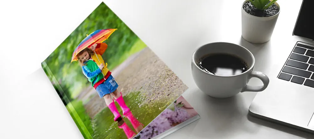 What is a Photo Book. Photo book with cup of coffee and laptop.