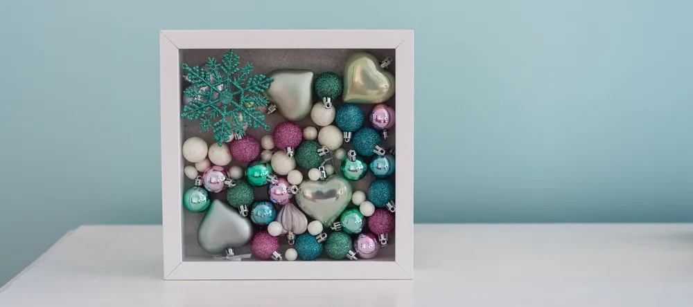 What is a Floating Frame for Canvas. Shadowbox frame containing baubles.