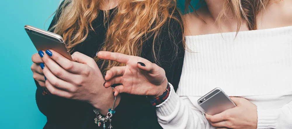 How to edit photos: two women looking at their smartphones