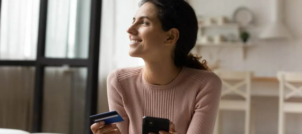 How to edit photos: a woman holding a smartphone and a credit card