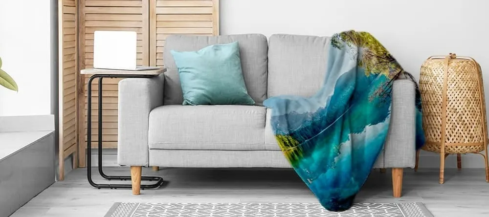 What is a Throw Blanket. Sofa with cushion and printed blanket.