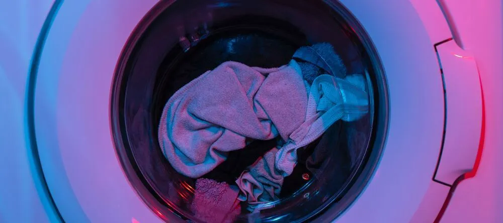 What is a Throw Blanket. Washing machine with fabrics inside.