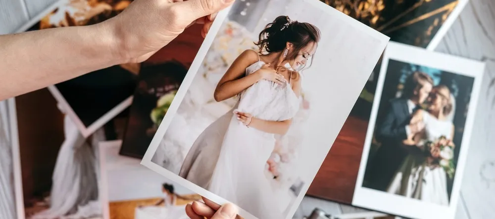 Glossy vs Matte Prints. Photo print held up over pile of photo prints.