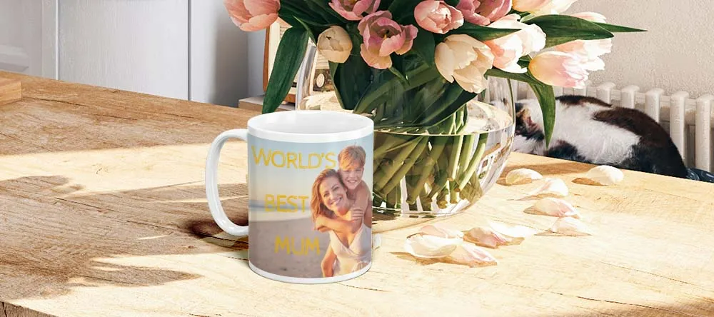 Mugs with Personalised Text. Mug with text on table with flowers.
