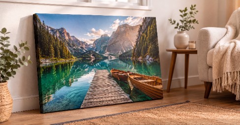 A gallery-wrapped canvas print of a Cornish coastal sunset with a rock arch, resting on an oak sideboard in a warm, sunlit UK living room